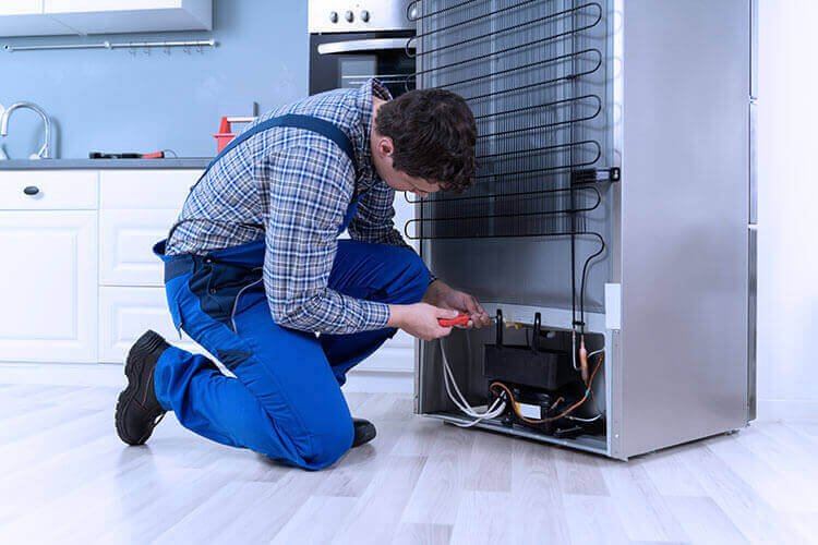 Refrigerator service technician at work